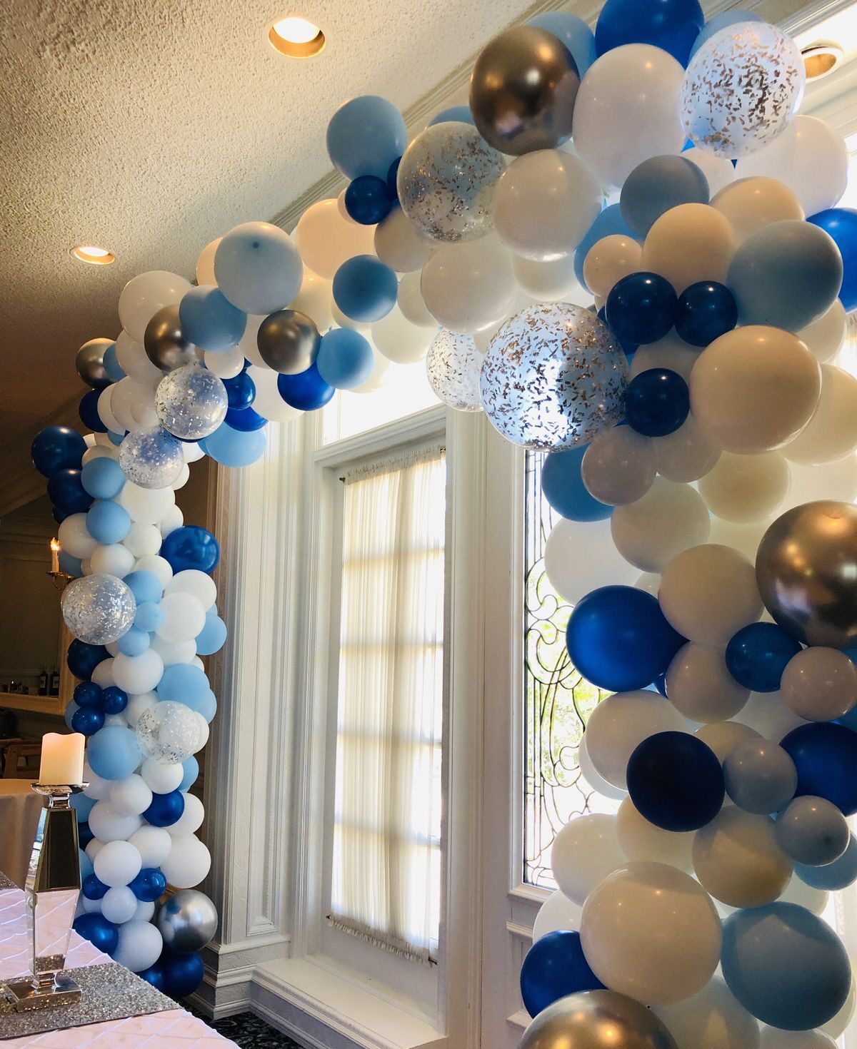 Balloon arch in blue, white, and silver colors over doorway by Blue Luna Events in Tucson event decor tucson balloon styling